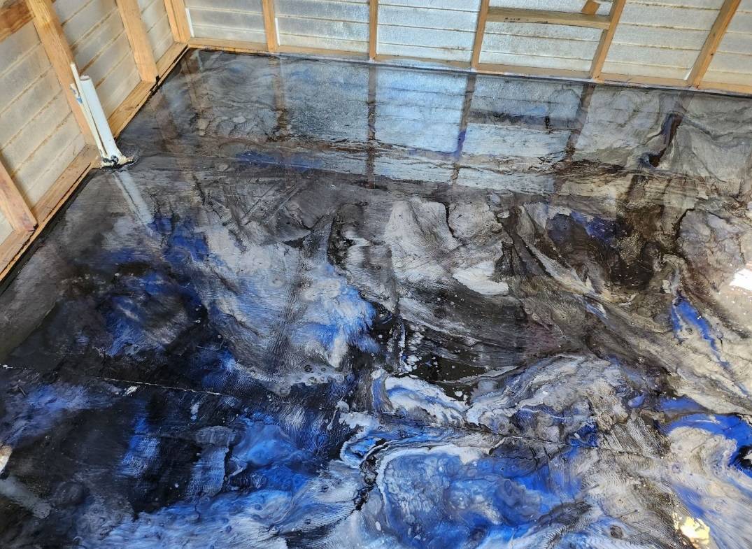 Glossy blue, black, and silver metallic epoxy floor inside a shed